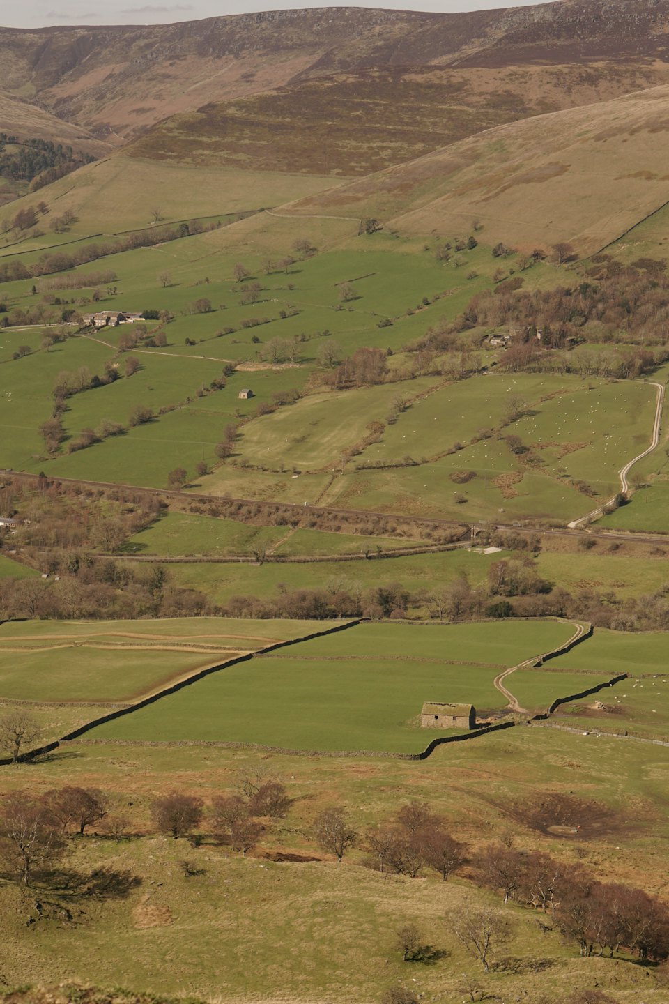 Green rural fields divided by stone walls in a valley.